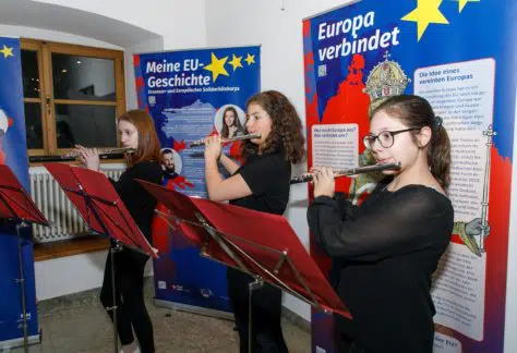 Drei junge Frauen spielen mit ihren Querflöten bei der EU-Ausstellung.