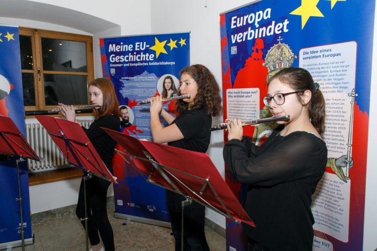 Drei junge Frauen spielen mit ihren Querflöten bei der EU-Ausstellung.