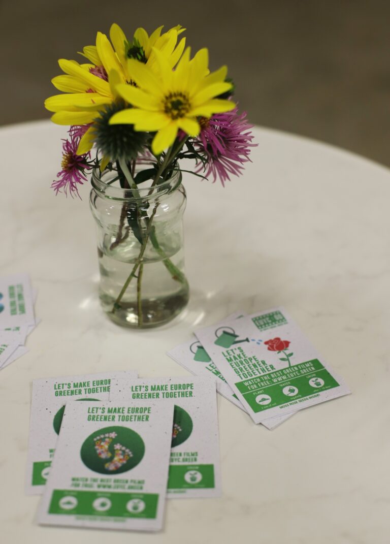 Symbolbild mit Blumen und Werbung für EU Youth Cinema